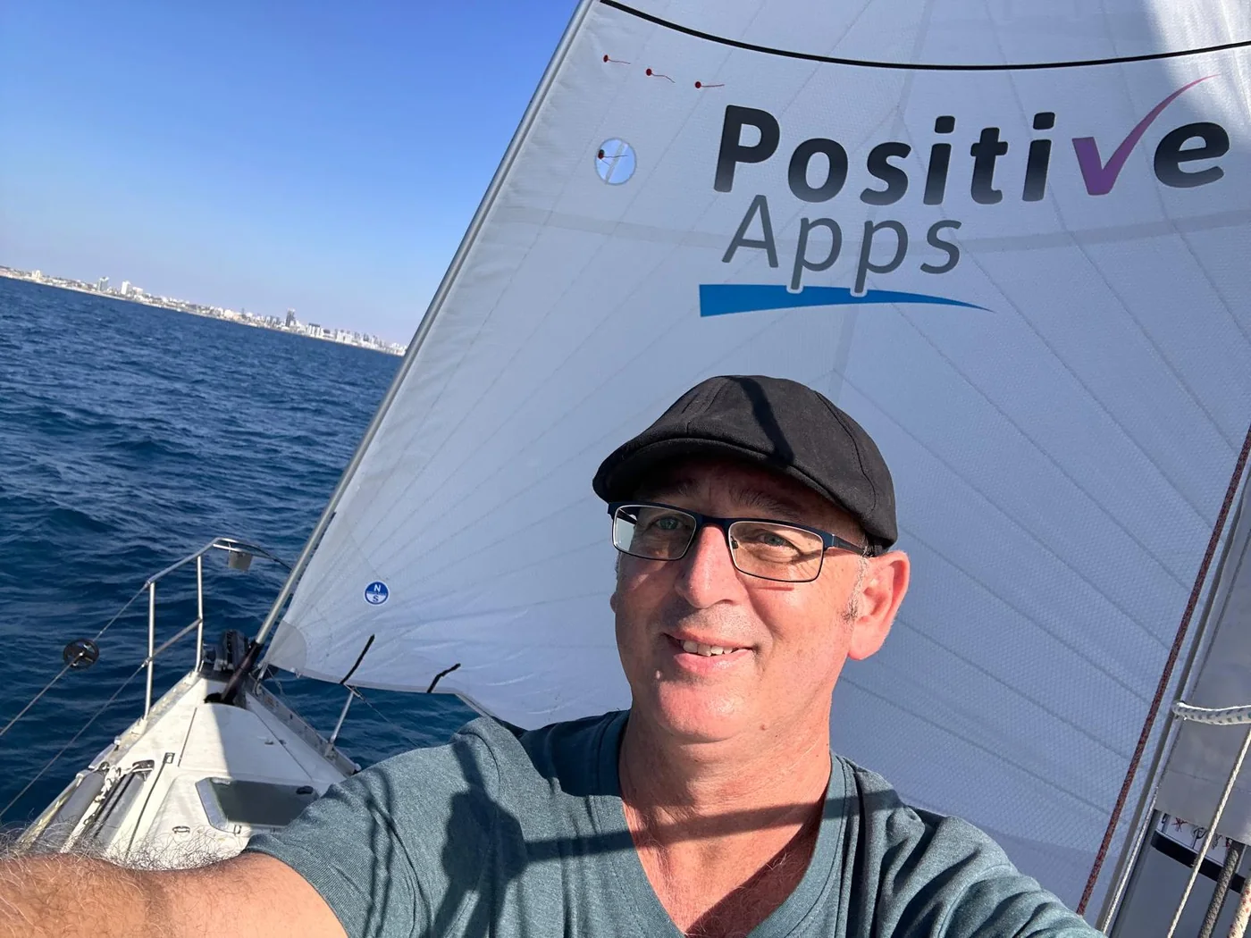 עמי חלפון בהפלגה כשמאחוריו מפרש Positive-Apps
